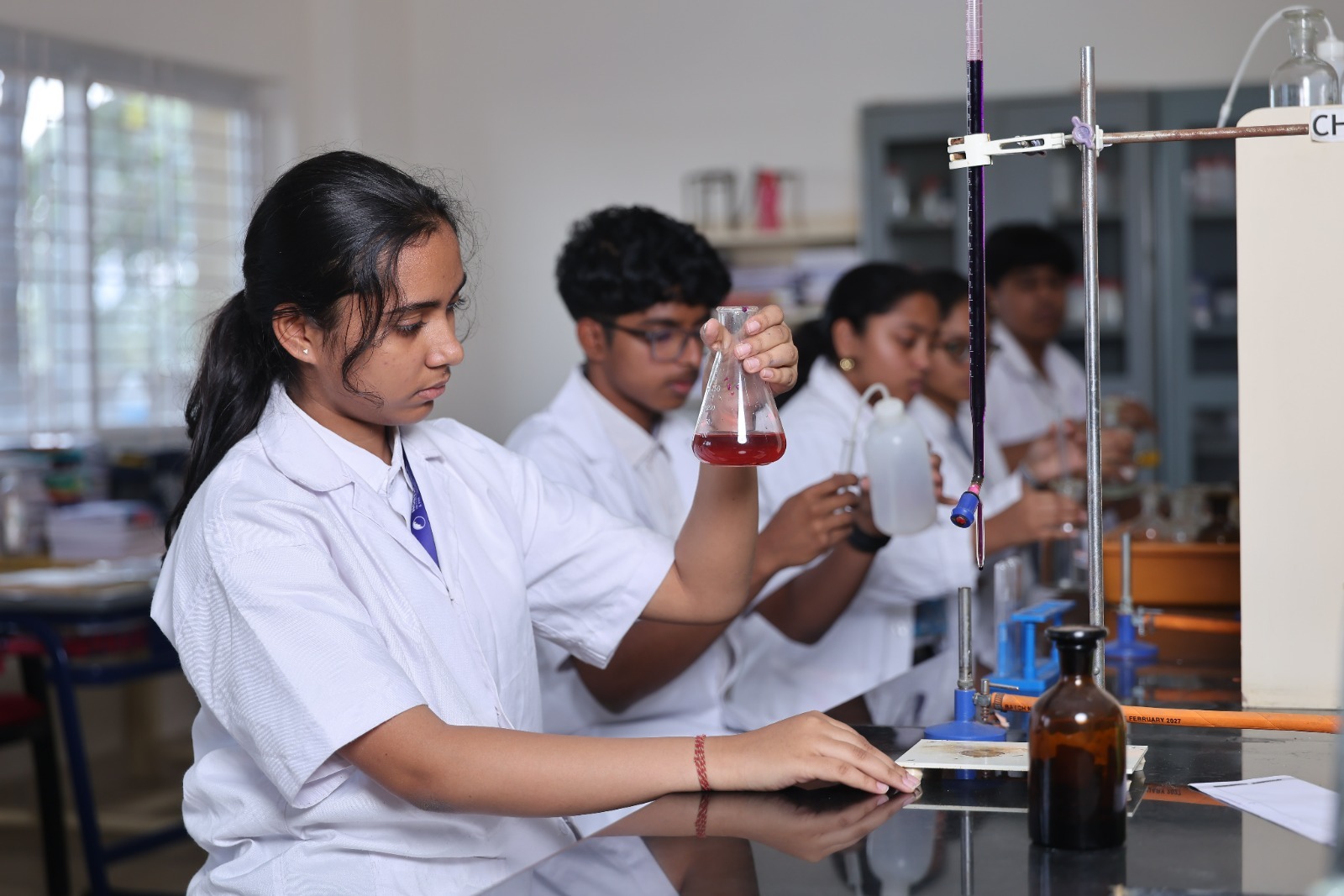 Students conducting chemistry experiments in a well equipped science laboratory